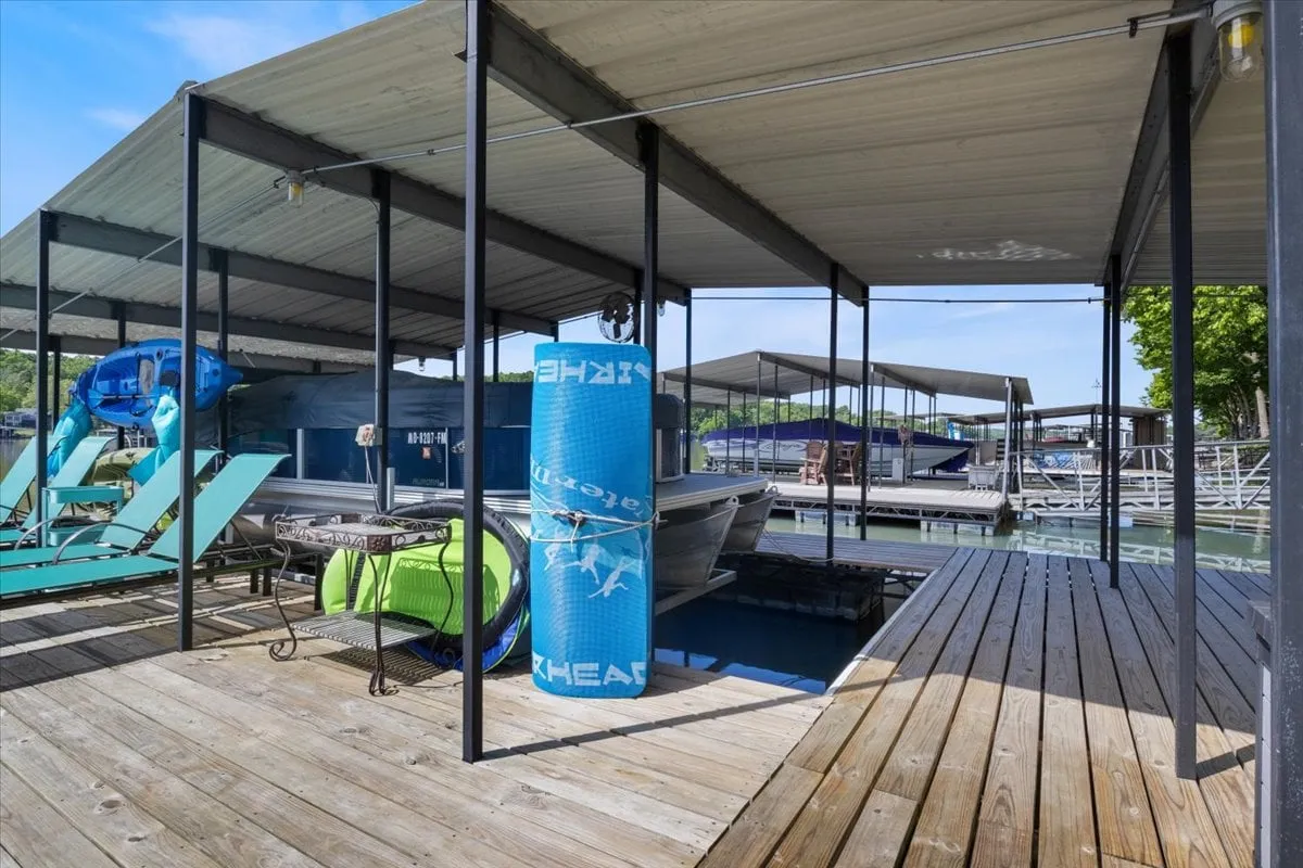 A lively marina scene with a boat docked, bright kayaks ready for use, and an outdoor seating area. This image conveys both the recreational water activities available and relaxed outdoor gathering spaces.